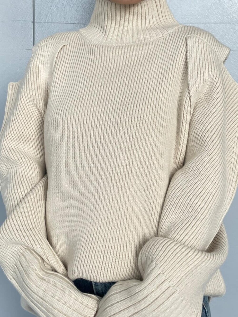 ホワイト系のニット/セーター、ブルー系のデニムパンツ、グレー系のブルゾンを着用したレディースの秋コーディネートの3枚目の写真