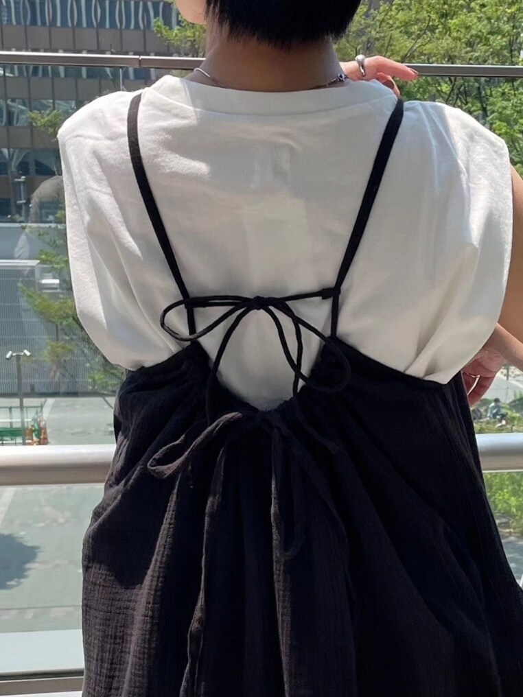 ホワイト系のタンクトップ、ブラック系のワンピース、ブラック系のサンダルを着用したレディースの夏コーディネートの3枚目の写真