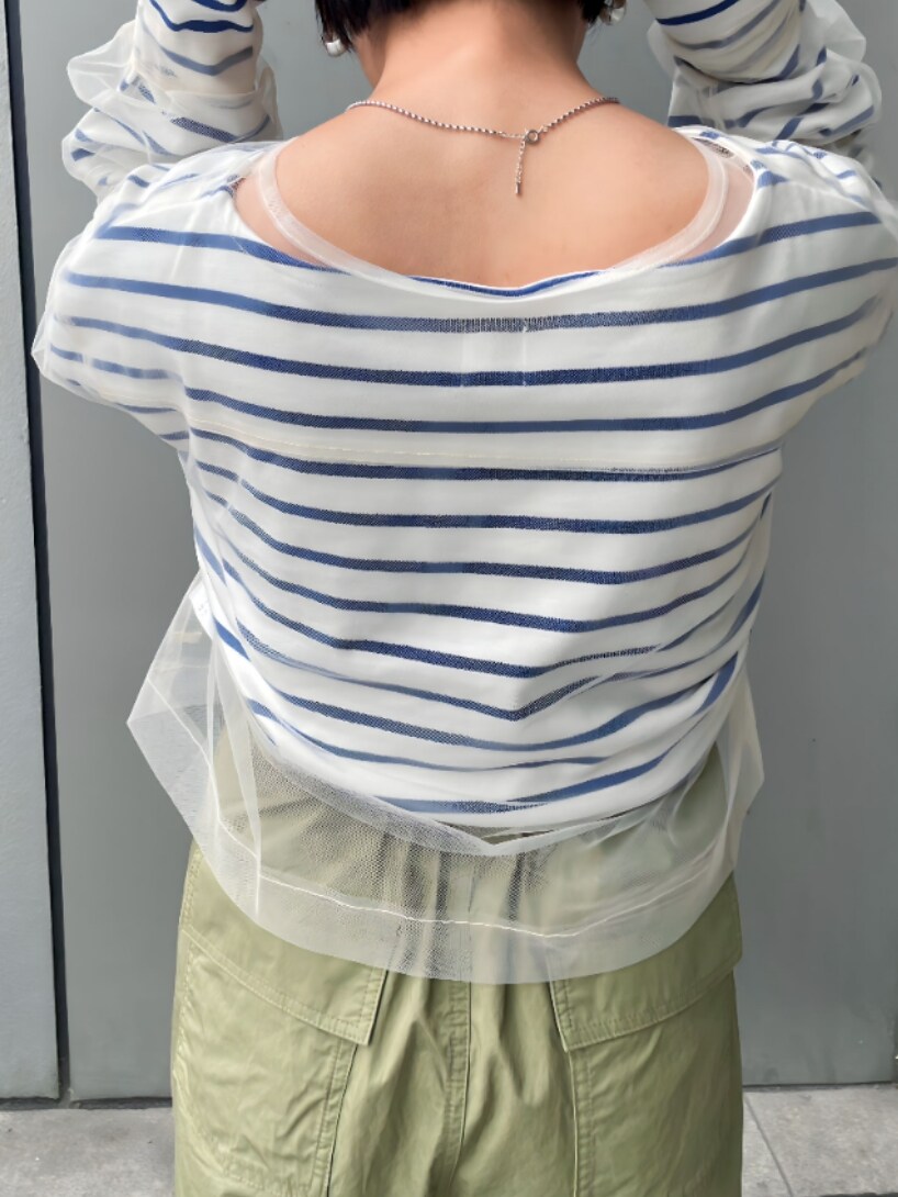 ベージュ系のステンカラーコート、ホワイト系のTシャツ/カットソー、グリーン系のその他パンツを着用したレディースの冬コーディネートの4枚目の写真