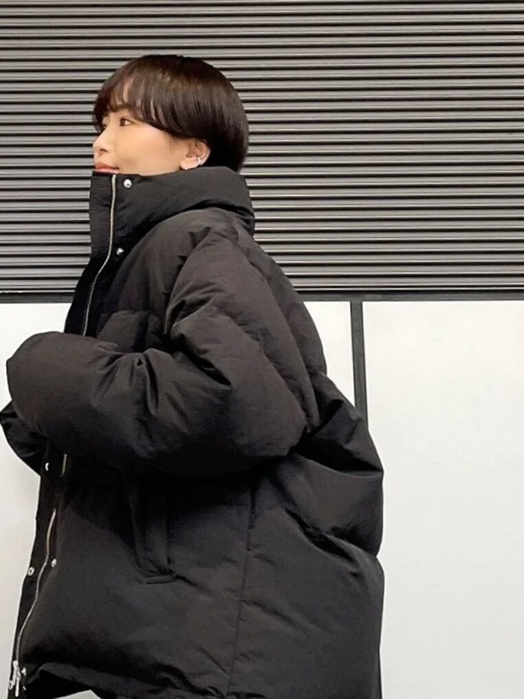 ブラック系のダウンジャケット/コート、グリーン系のスウェット、グレー系のスカートを着用したレディースの秋コーディネートの3枚目の写真