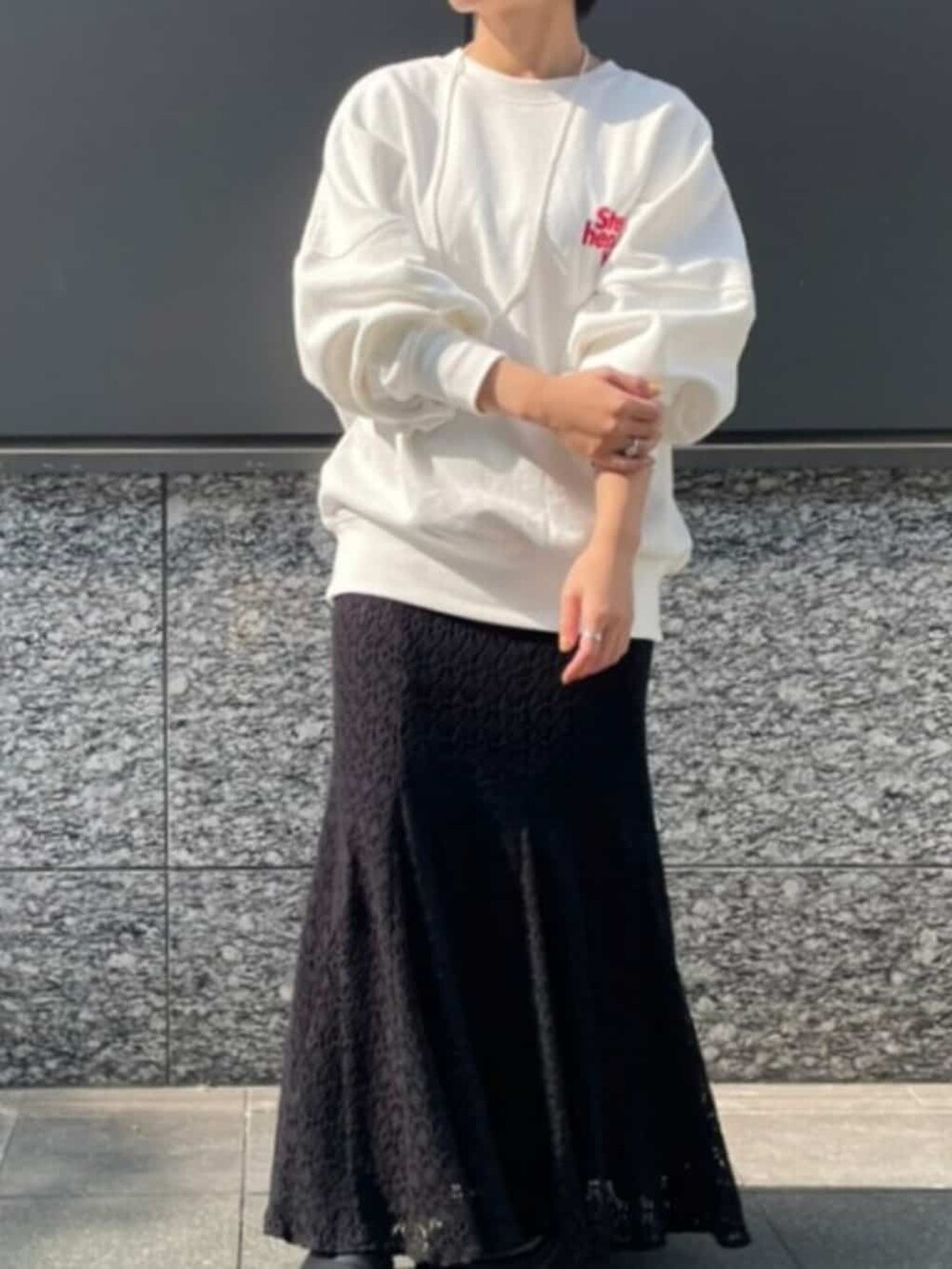 ブラック系のスカート、ホワイト系のスウェット、ホワイト系のネックレスを着用したレディースの冬コーディネートの3枚目の写真