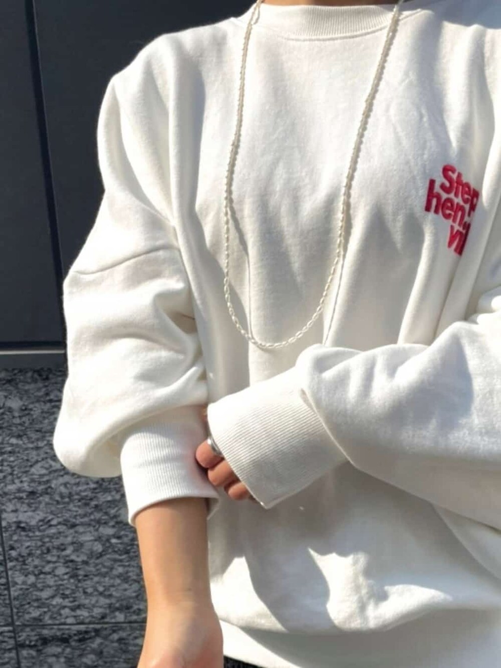 ブラック系のスカート、ホワイト系のスウェット、ホワイト系のネックレスを着用したレディースの冬コーディネートの2枚目の写真