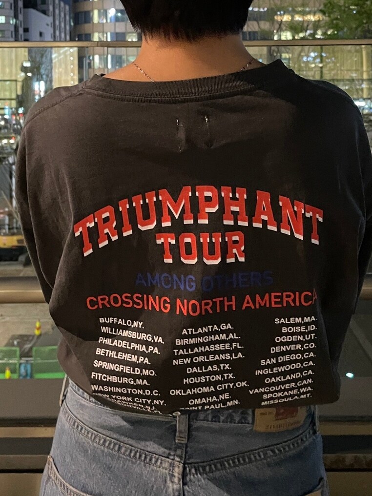 グレー系のTシャツ/カットソー、ホワイト系のスニーカー、ブルー系のデニムパンツを着用したレディースの春コーディネートの3枚目の写真