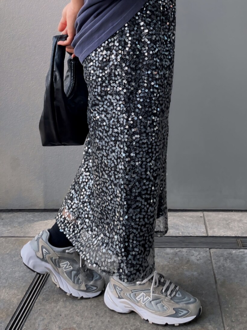 ブルー系のTシャツ/カットソー、ブラック系のスカート、ブラック系のハンドバッグを着用したレディースの春コーディネートの5枚目の写真