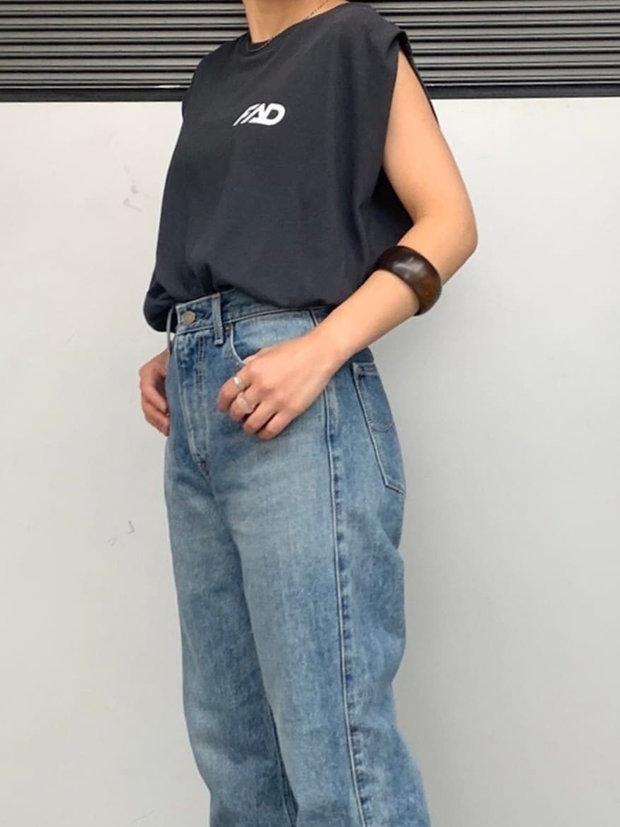 ブルー系のデニムパンツ、グレー系のタンクトップ、ブラウン系のブレスレットを着用したレディースの春コーディネートの4枚目の写真
