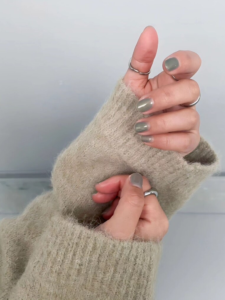 グレー系のニット/セーター、ブルー系のデニムパンツを着用したレディースの冬コーディネートの3枚目の写真