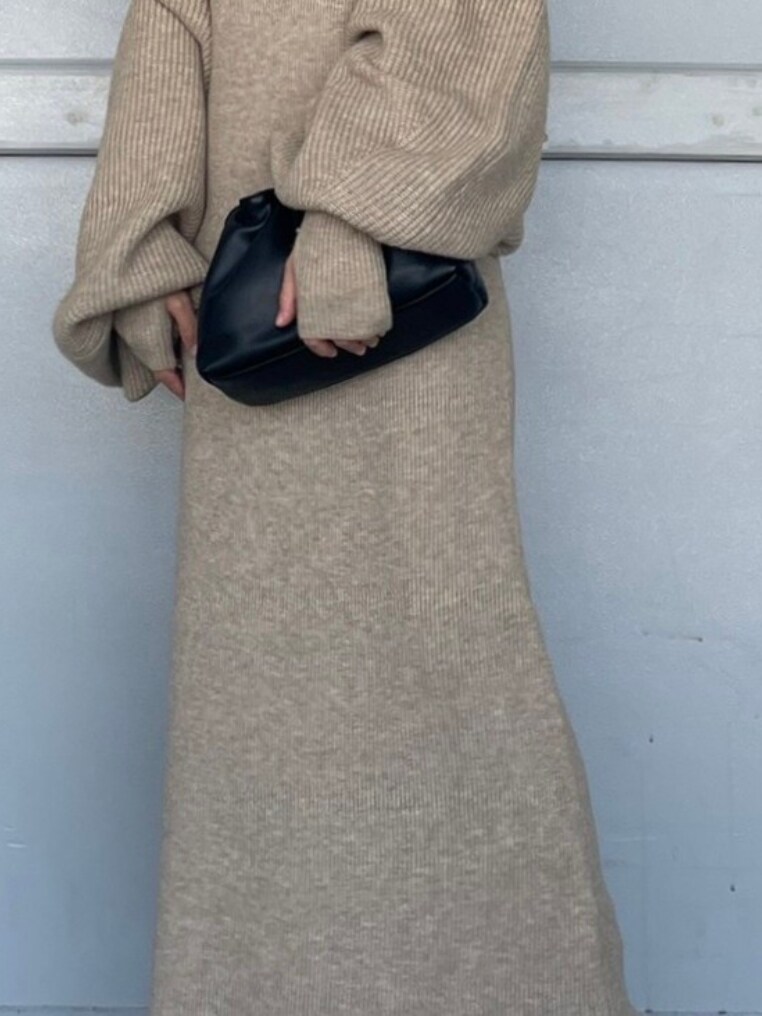 ブラック系のクラッチバッグ、ブラック系のブーツ、グレー系のワンピースを着用したレディースの秋コーディネートの4枚目の写真