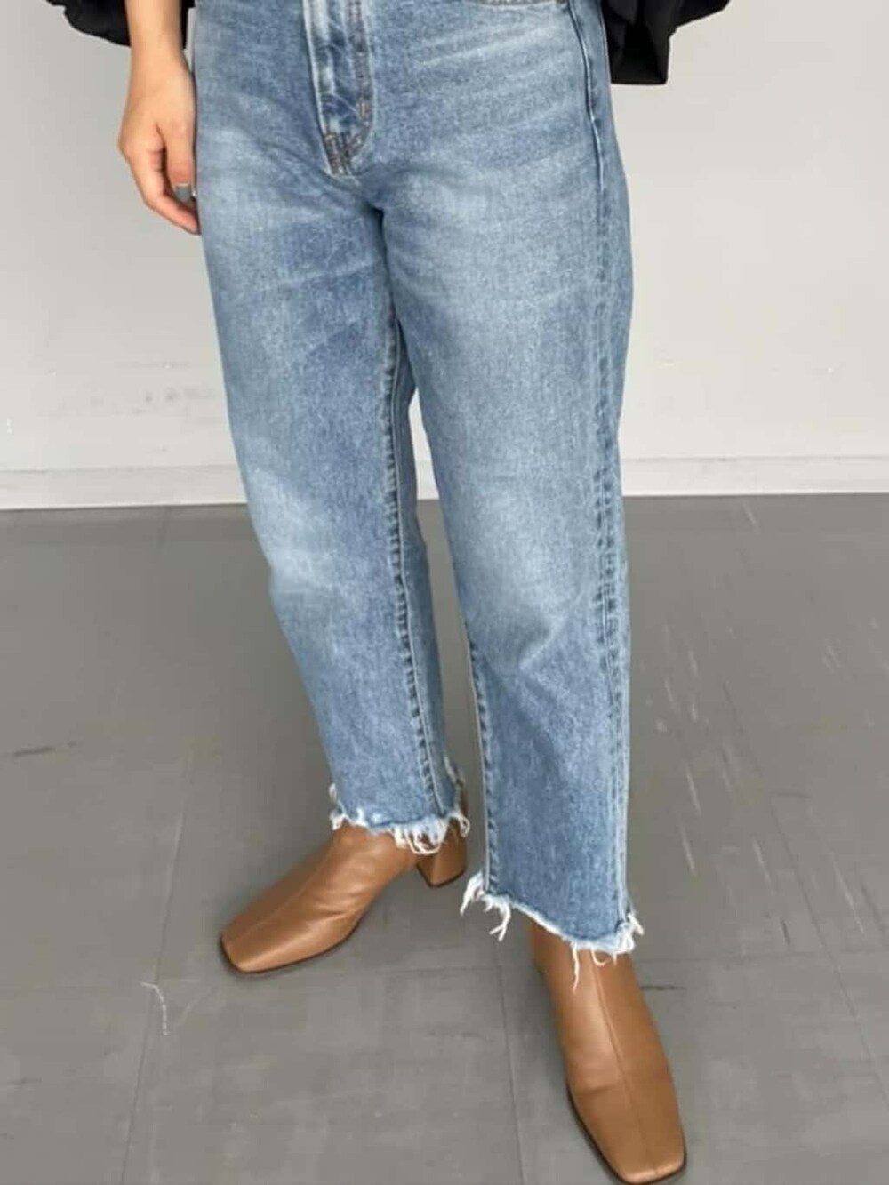 ブラック系のシャツ/ブラウス、ブラウン系のブーツ、ブルー系のデニムパンツを着用したレディースの夏コーディネートの3枚目の写真