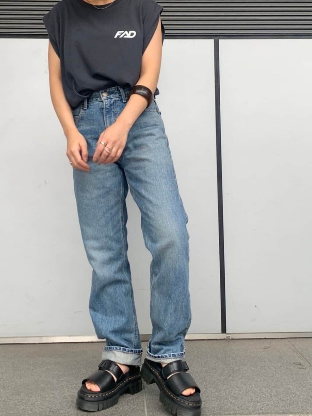 ブルー系のデニムパンツ、グレー系のタンクトップ、ブラウン系のブレスレットを着用したレディースの春コーディネートの3枚目の写真