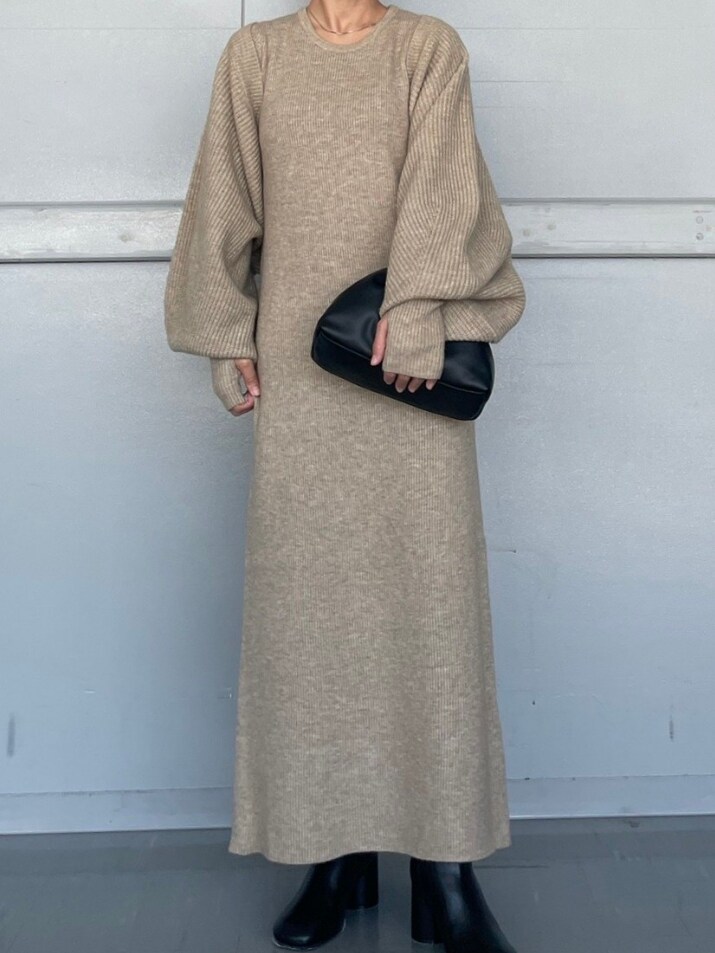 ブラック系のクラッチバッグ、ブラック系のブーツ、グレー系のワンピースを着用したレディースの秋コーディネートの3枚目の写真