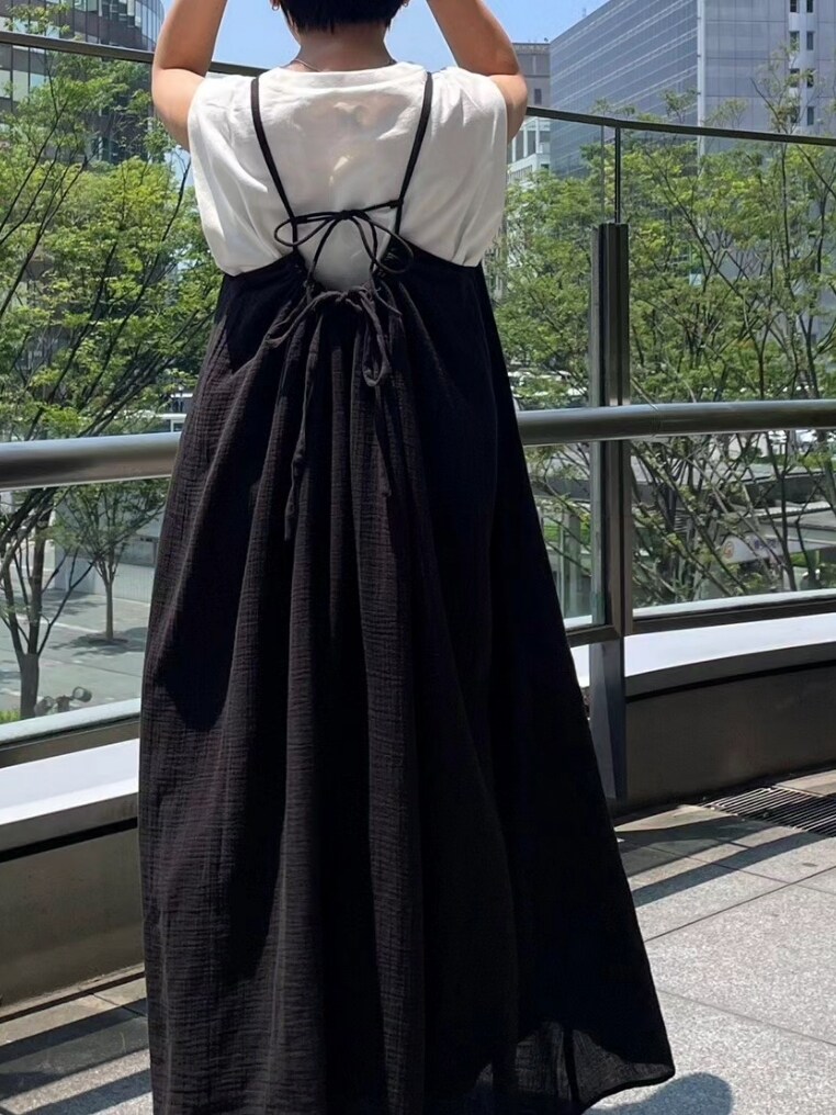 ホワイト系のタンクトップ、ブラック系のワンピース、ブラック系のサンダルを着用したレディースの夏コーディネートの2枚目の写真