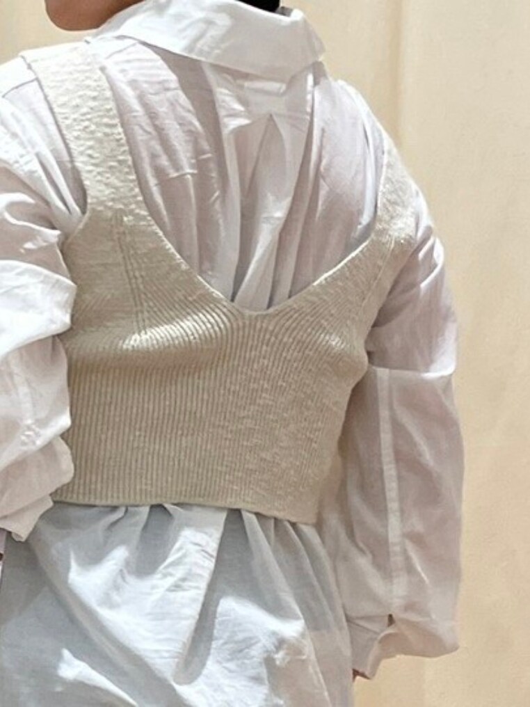 ホワイト系のベスト、ホワイト系のシャツ/ブラウス、ブラック系のハンドバッグを着用したレディースの春コーディネートの3枚目の写真