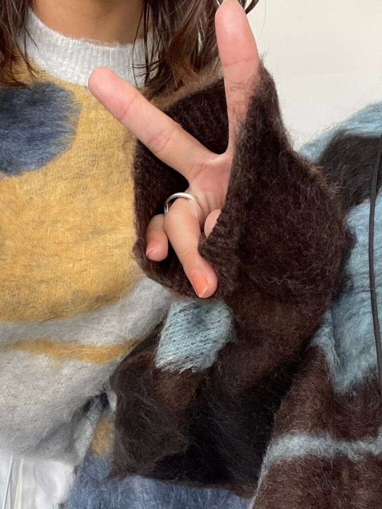 ブラウン系のニット/セーター、ブラック系のショルダーバッグ、グレー系のスカートを着用したレディースの秋コーディネートの4枚目の写真