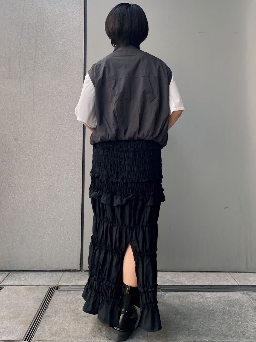 グレー系のベスト、ブラック系のスカートを着用したレディースの夏コーディネートの3枚目の写真