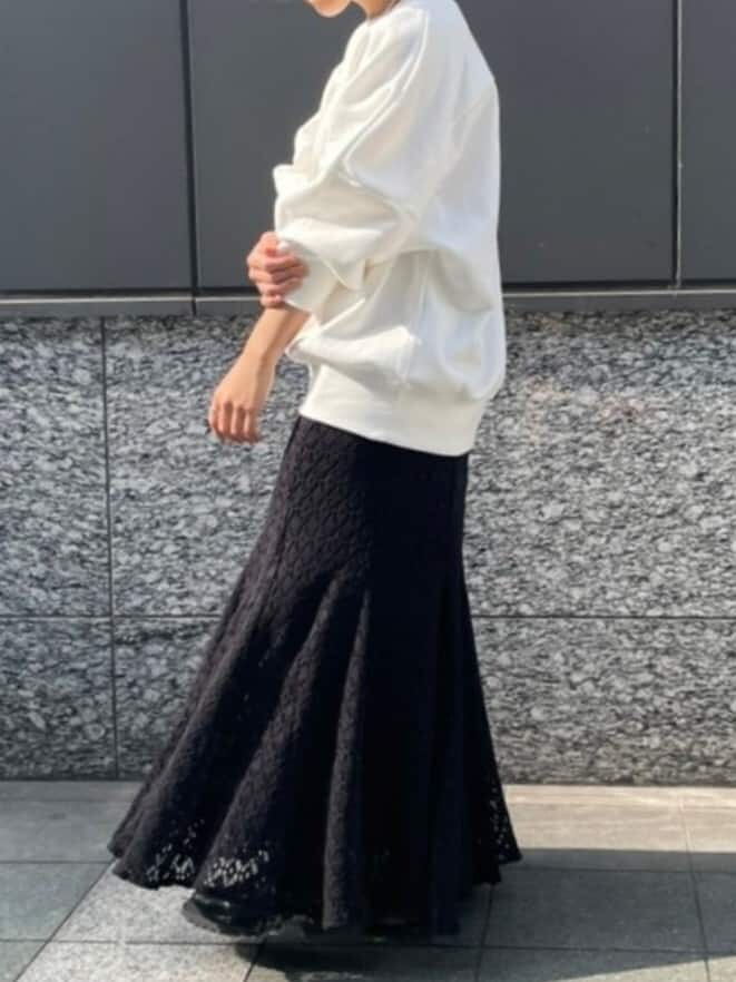 ブラック系のスカート、ホワイト系のスウェット、ホワイト系のネックレスを着用したレディースの冬コーディネートの4枚目の写真