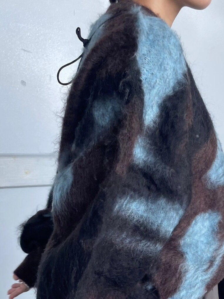 ブラウン系のニット/セーター、ブラック系のショルダーバッグ、グレー系のスカートを着用したレディースの秋コーディネートの3枚目の写真