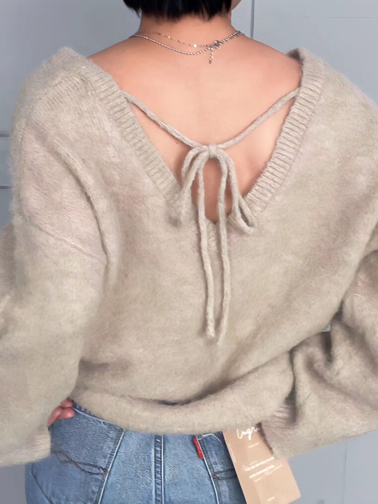 グレー系のニット/セーター、ブルー系のデニムパンツを着用したレディースの冬コーディネートの2枚目の写真