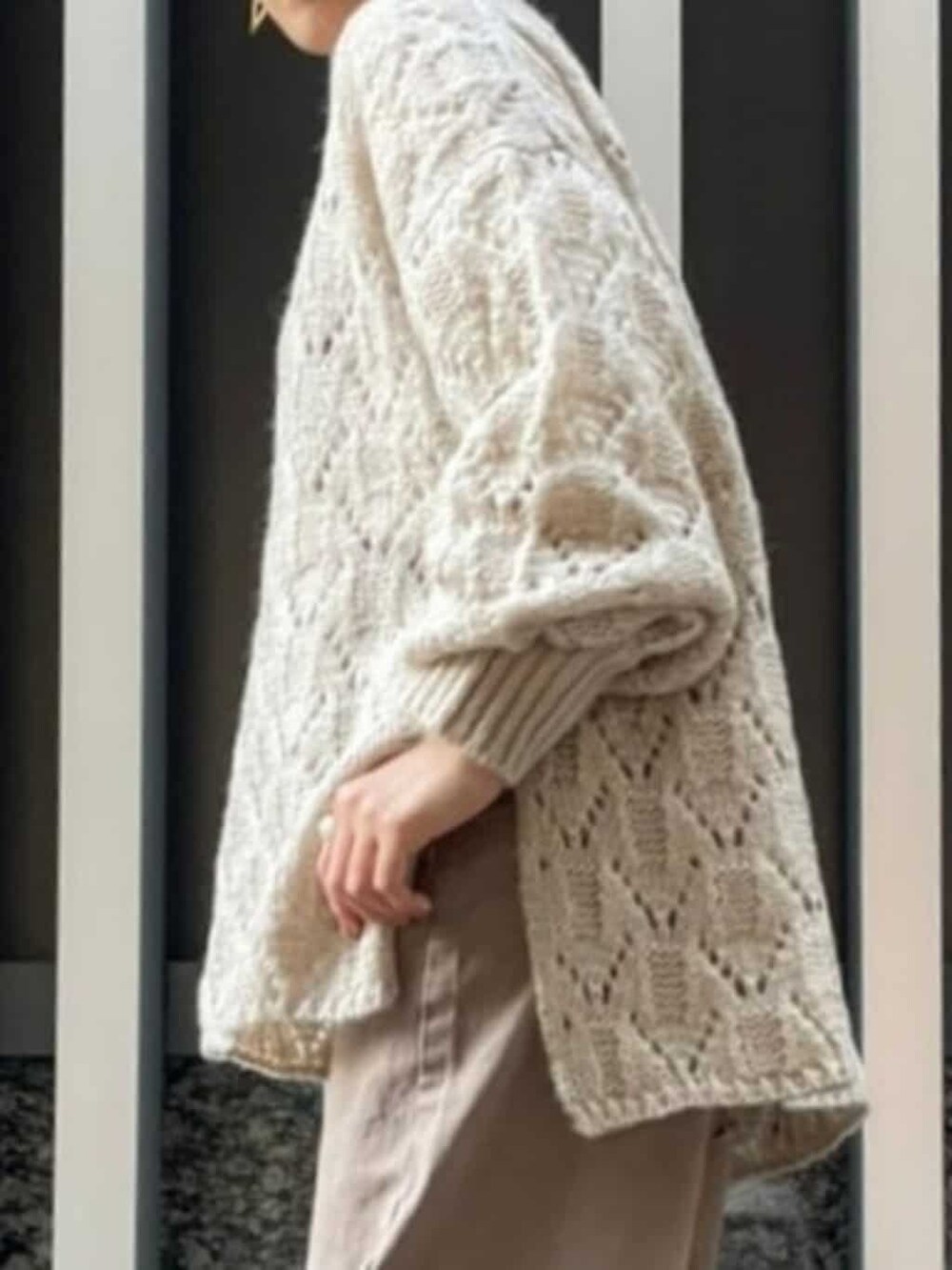 ベージュ系のデニムパンツ、ホワイト系のTシャツ/カットソー、ベージュ系のニット/セーターを着用したレディースの秋コーディネートの2枚目の写真