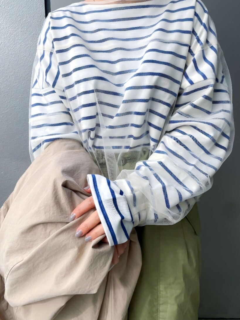 ベージュ系のステンカラーコート、ホワイト系のTシャツ/カットソー、グリーン系のその他パンツを着用したレディースの冬コーディネートの3枚目の写真