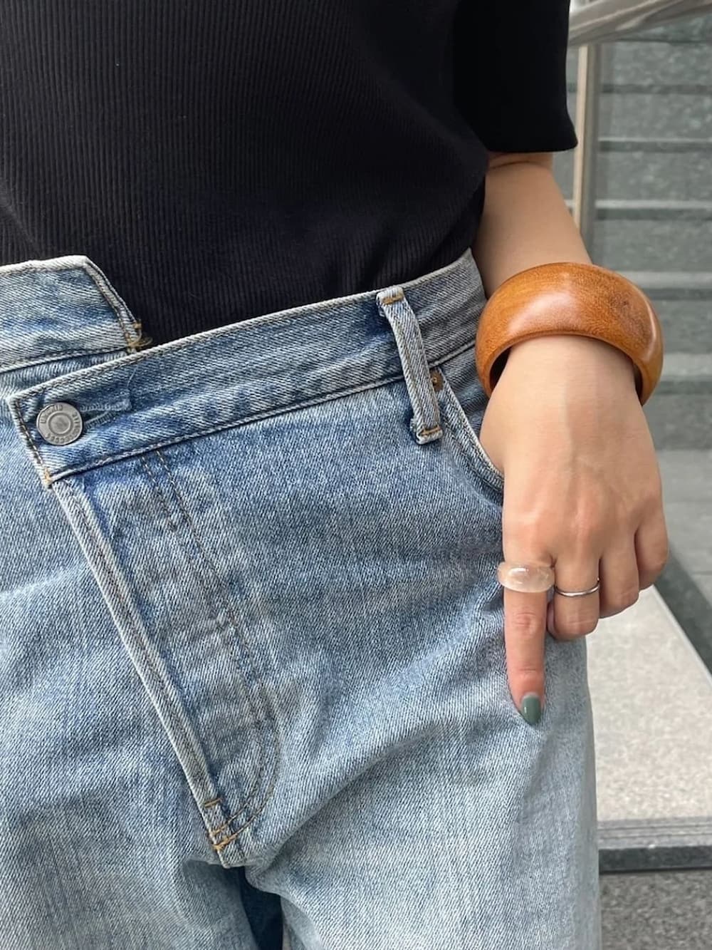 ブルー系のデニムパンツ、ブラック系のTシャツ/カットソー、ブラック系のサンダルを着用したレディースの夏コーディネートの3枚目の写真