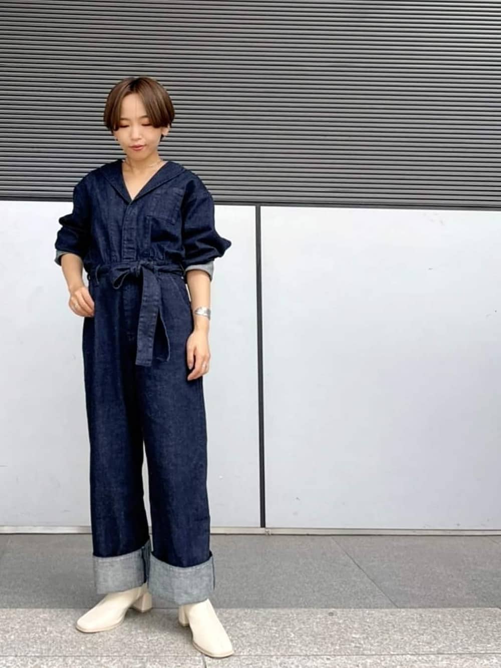 ブルー系のつなぎ/オールインワン、ホワイト系のブーツ、シルバー系のブレスレットを着用したレディースの夏コーディネートの2枚目の写真