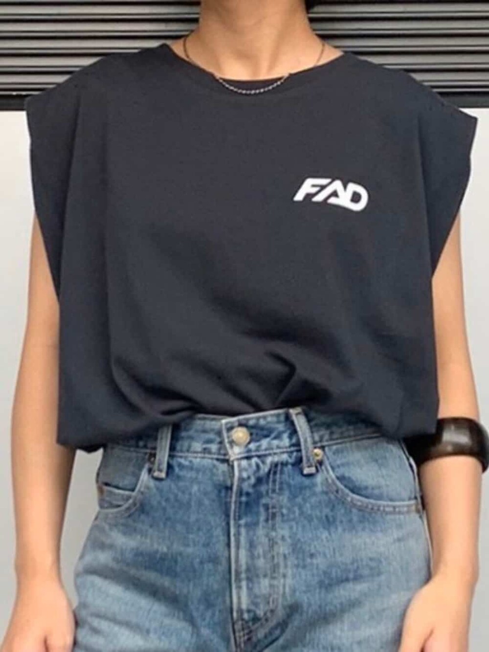 ブルー系のデニムパンツ、グレー系のタンクトップ、ブラウン系のブレスレットを着用したレディースの春コーディネートの2枚目の写真