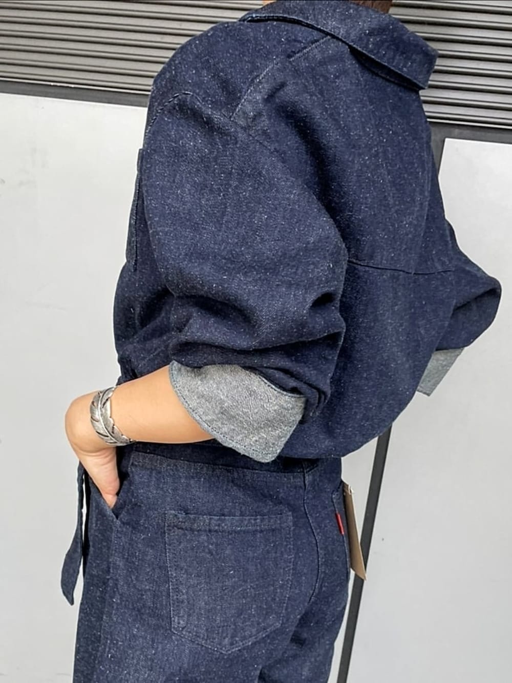 ブルー系のつなぎ/オールインワン、ホワイト系のブーツ、シルバー系のブレスレットを着用したレディースの夏コーディネートの3枚目の写真