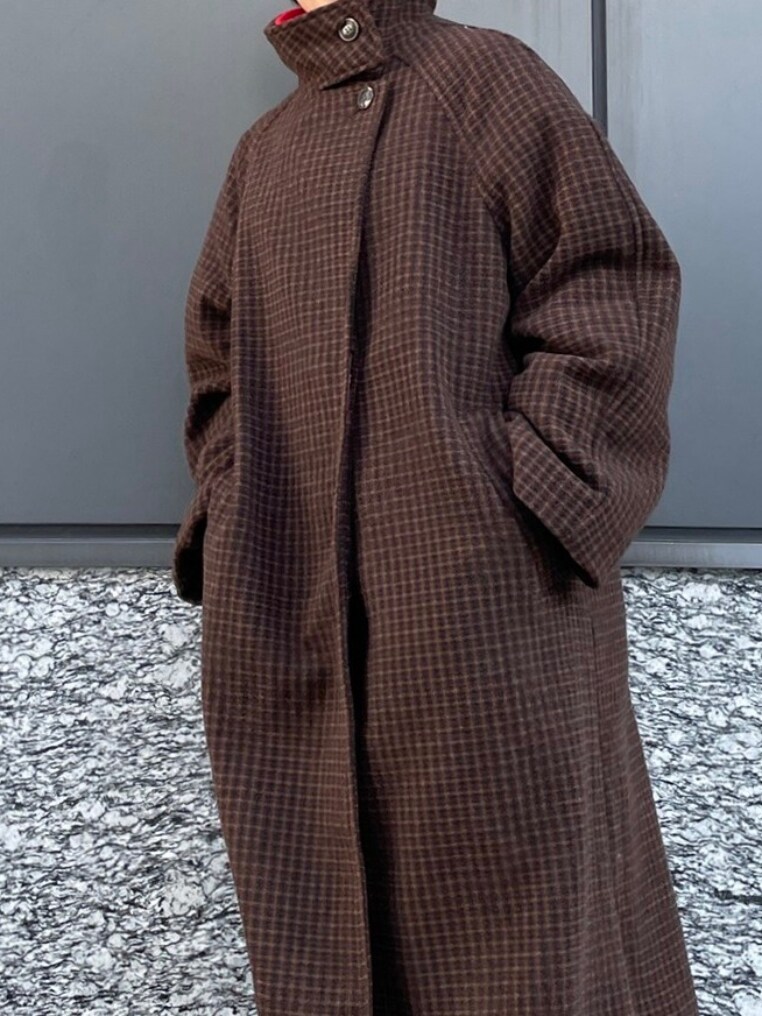 ブラウン系のその他アウター、レッド系のニット/セーター、ブルー系のデニムパンツを着用したレディースの秋コーディネートの2枚目の写真