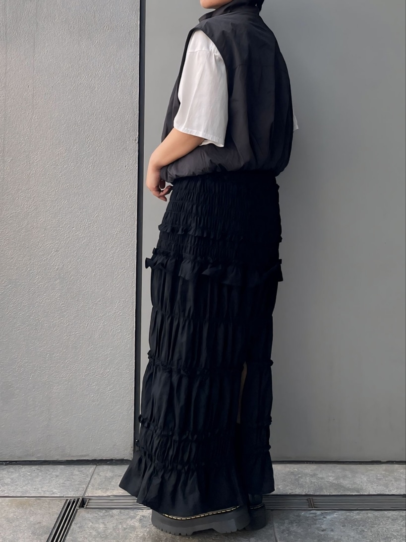 グレー系のベスト、ブラック系のスカートを着用したレディースの夏コーディネートの2枚目の写真