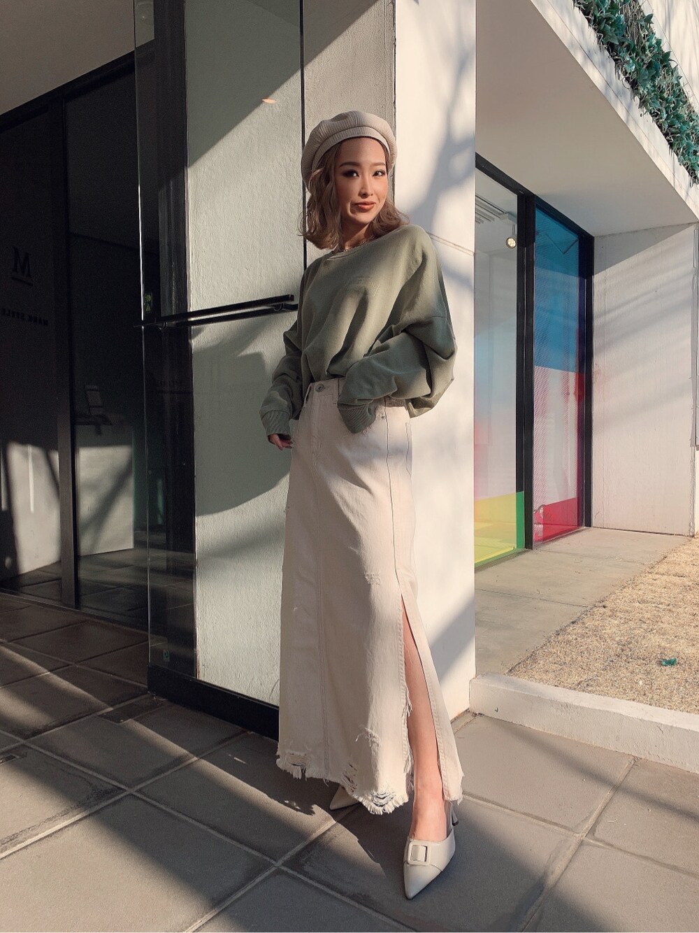 ホワイト系のパンプス、ベージュ系のスウェット、ホワイト系のデニムスカートを着用したレディースの冬コーディネートの2枚目の写真