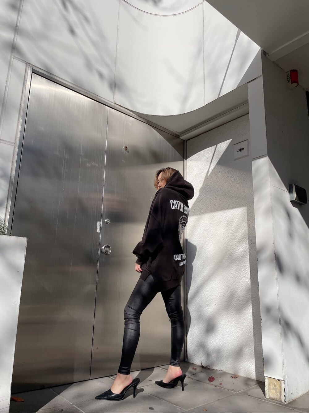 ブラック系のその他パンツ、グレー系のパーカーを着用したレディースの冬コーディネートの2枚目の写真