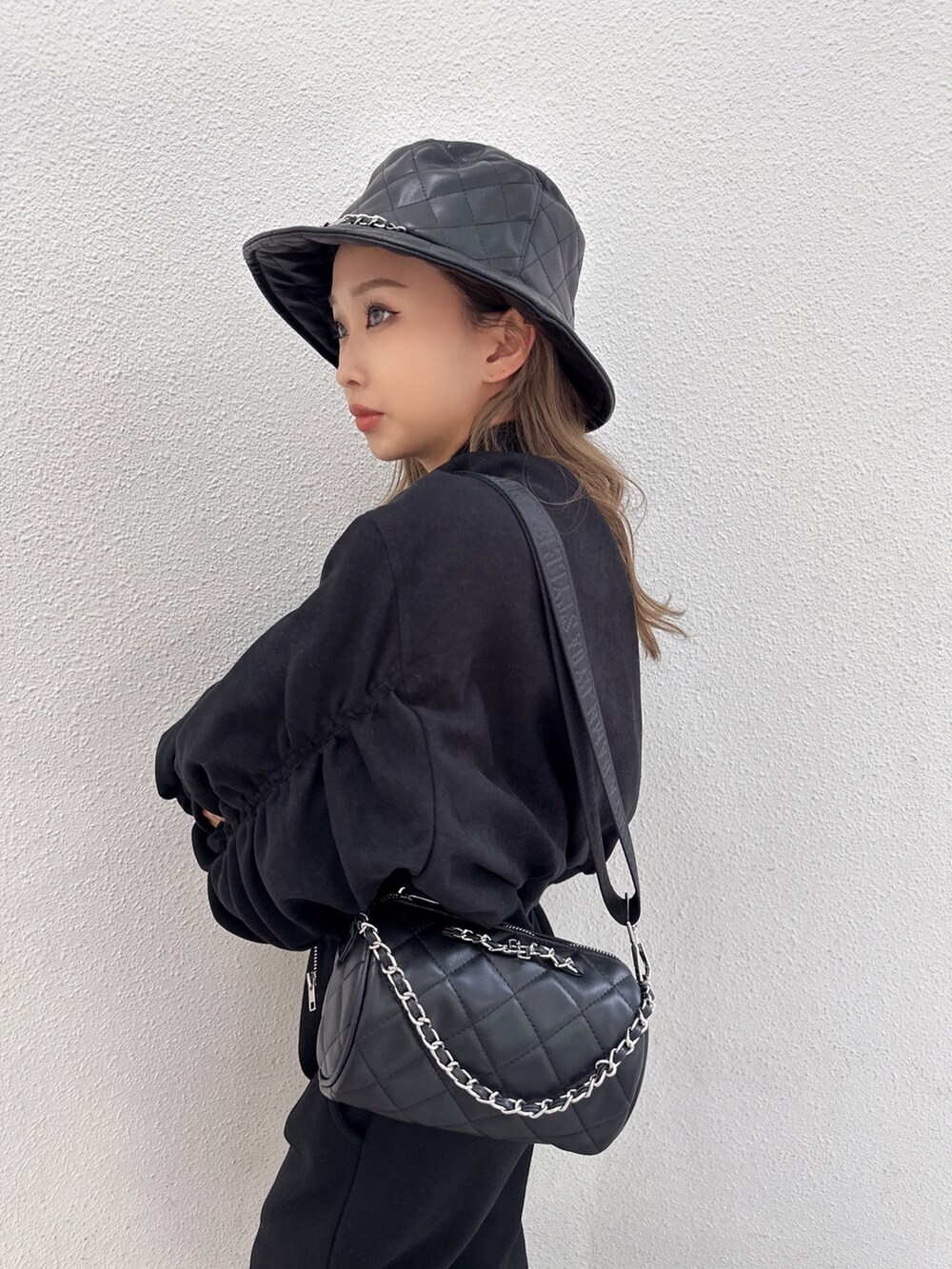 ブラック系のブルゾン、ブラック系のスウェットパンツ、ブラック系のハンドバッグを着用したレディースの冬コーディネートの2枚目の写真