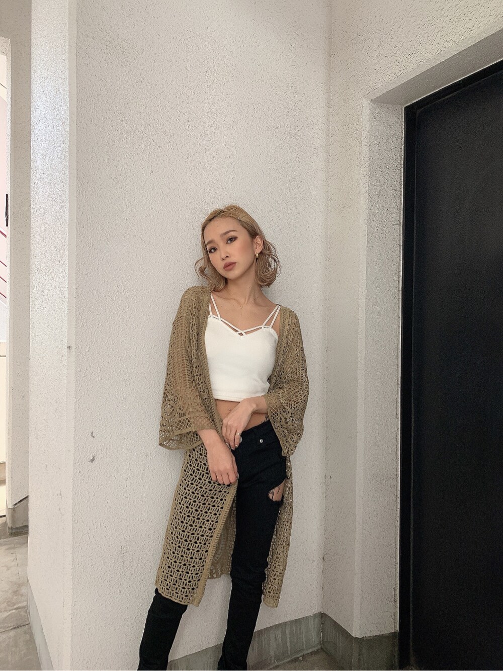 ベージュ系のカーディガン/ボレロ、ブラック系のチノパンツ、ホワイト系のキャミソールを着用したレディースの春コーディネートの3枚目の写真