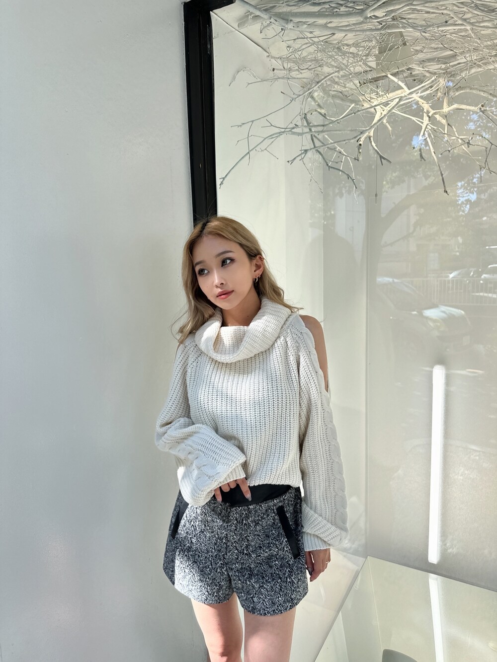 ホワイト系のニット/セーター、ブラック系のその他パンツ、ブラック系のブーツを着用したレディースの秋コーディネートの3枚目の写真