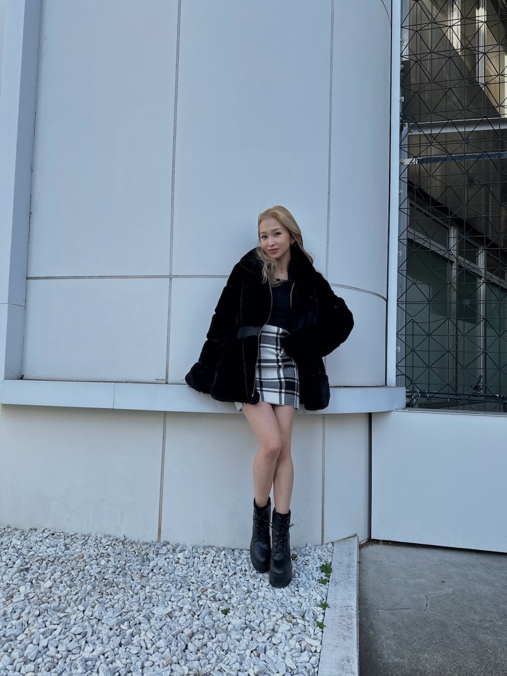 ブラック系のワンピース、ブラック系のその他アウター、ブラック系のブーツを着用したレディースの冬コーディネートの2枚目の写真