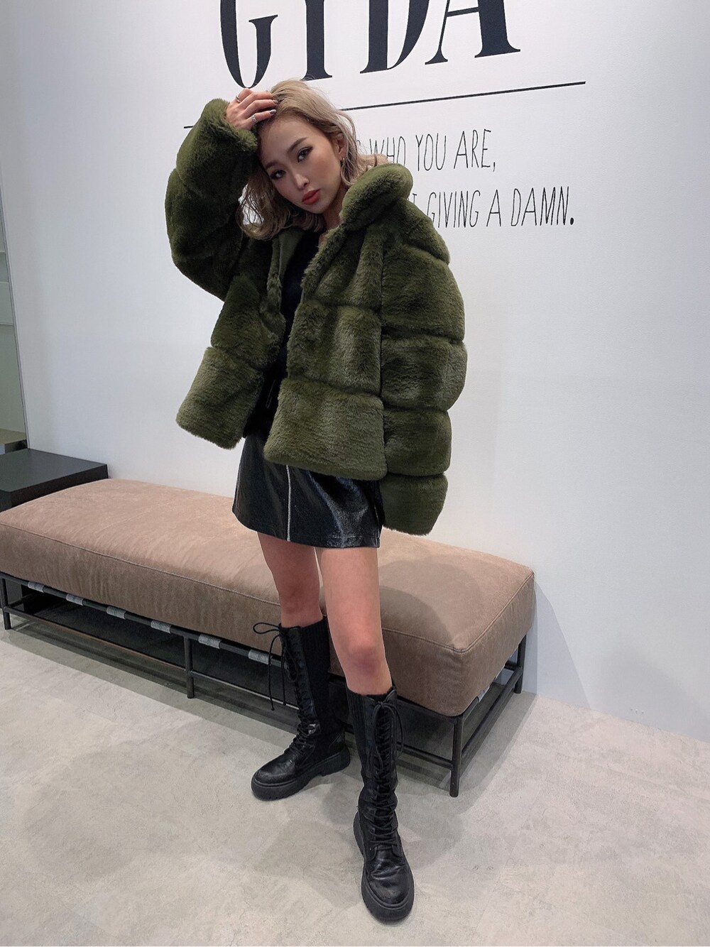 ブラック系のニット/セーター、ベージュ系のムートンコートを着用したレディースの冬コーディネートの2枚目の写真