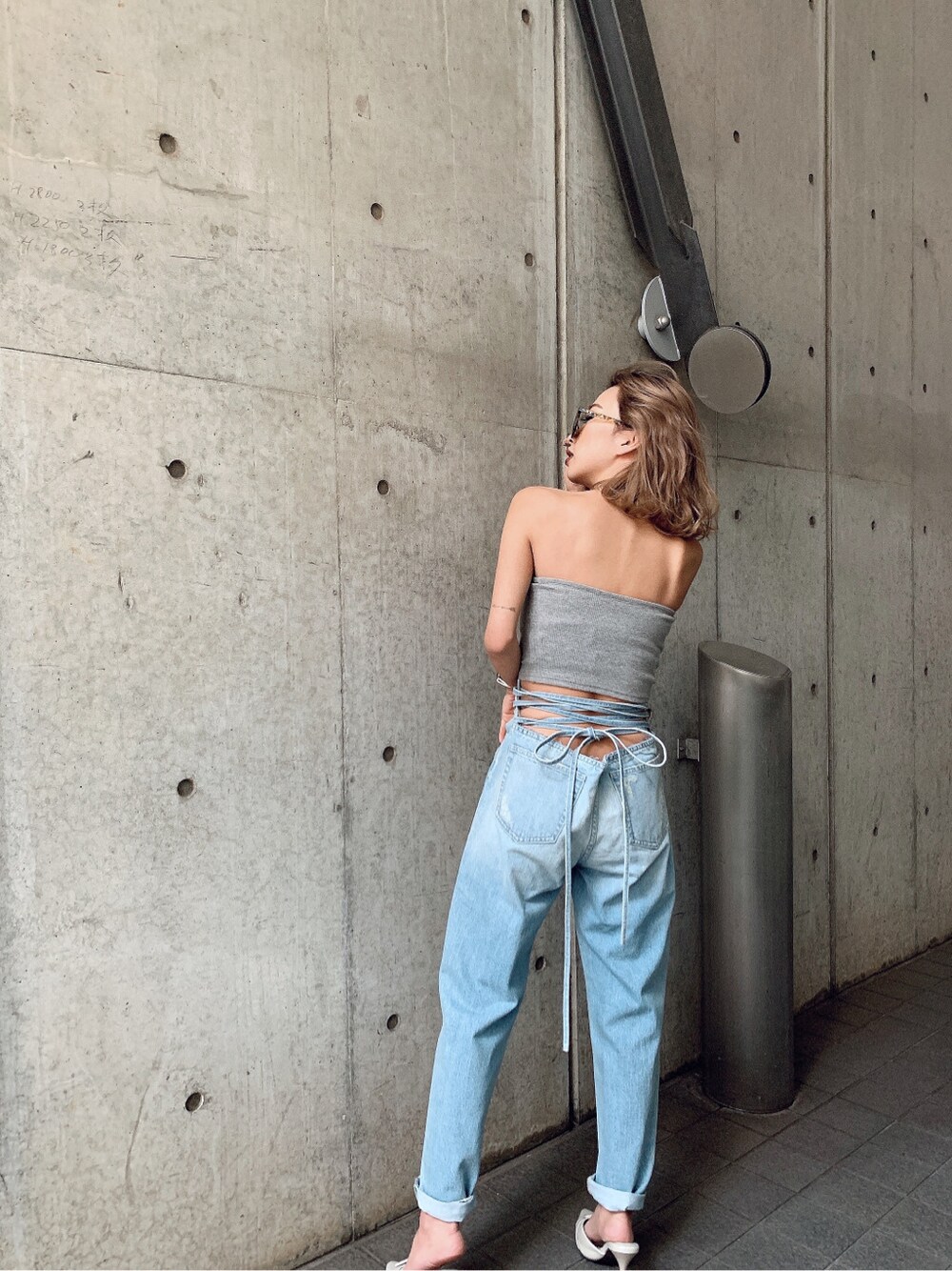 ホワイト系のパンプス、ブルー系のデニムパンツを着用したレディースの冬コーディネートの3枚目の写真