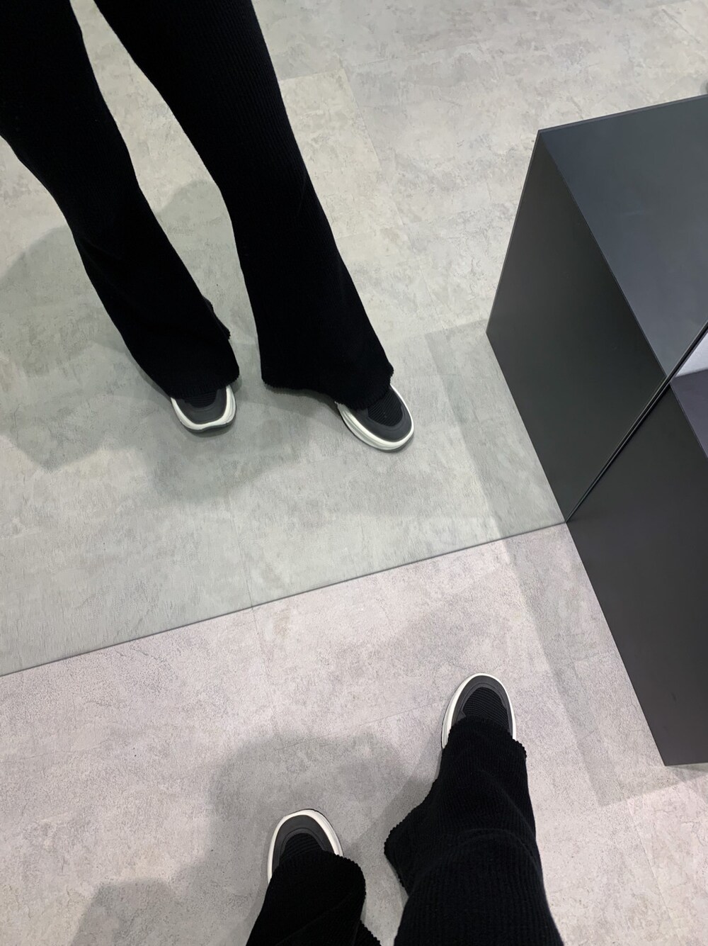 ブラック系のスニーカー、ホワイト系のパーカー、ブラック系のその他パンツを着用したレディースの冬コーディネートの2枚目の写真