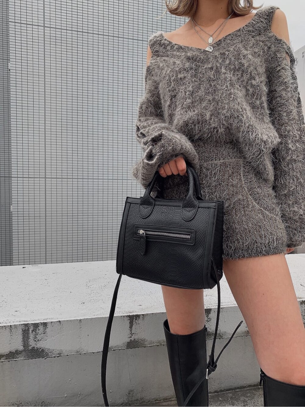 グレー系のその他パンツ、ブラック系のハンドバッグ、グレー系のニット/セーターを着用したレディースの夏コーディネートの2枚目の写真