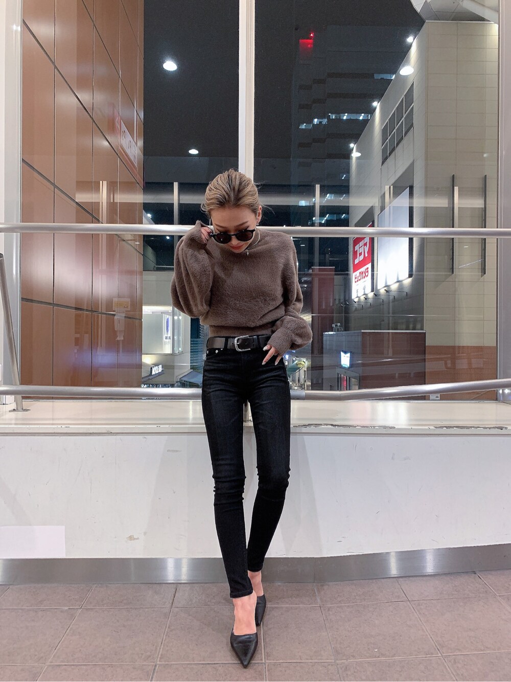 ブラック系のパンプス、ベージュ系のニット/セーター、ブラック系のベルトを着用したレディースの冬コーディネートの2枚目の写真