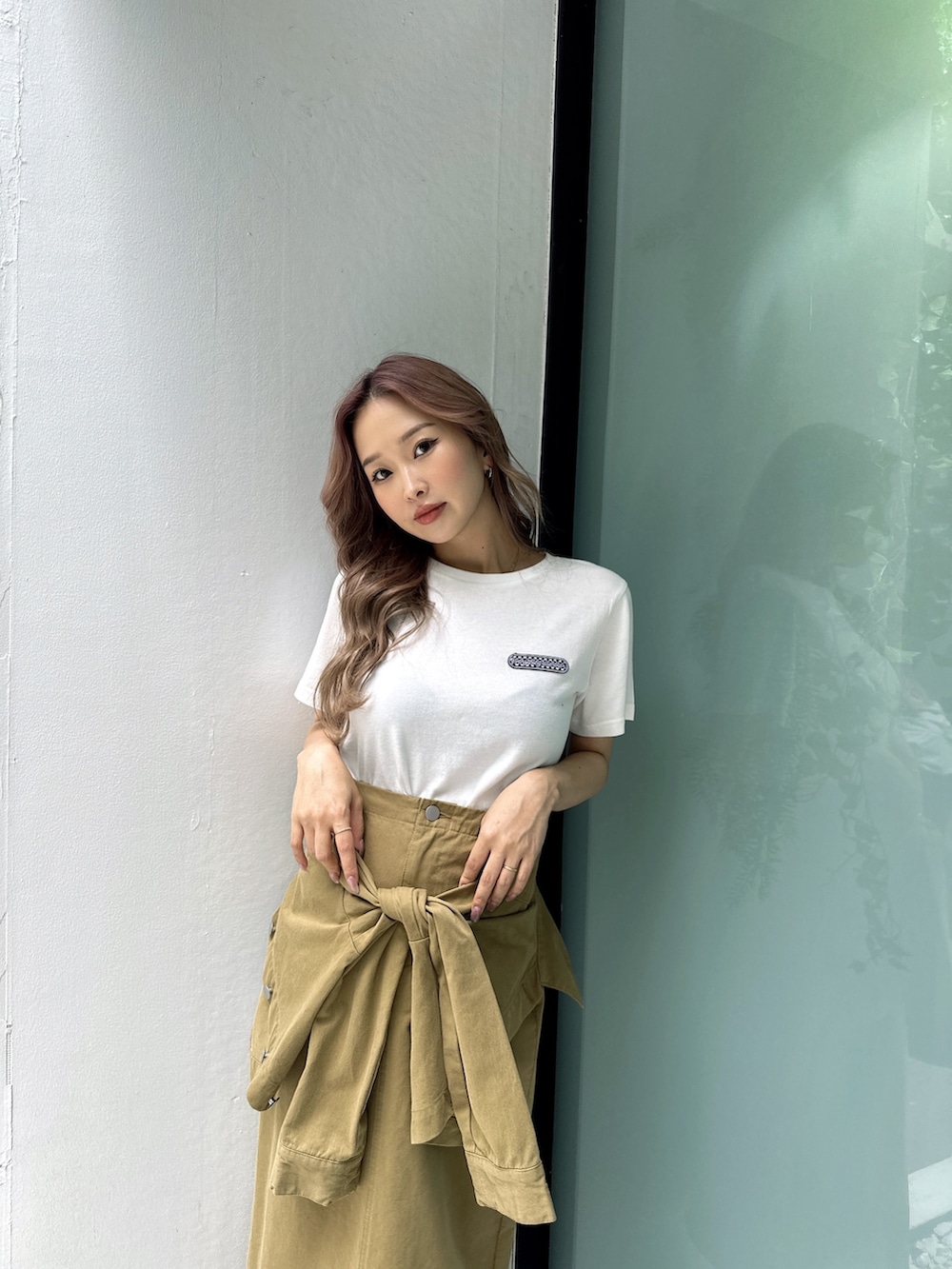 ホワイト系のTシャツ/カットソー、グリーン系のスカート、ベージュ系のサンダルを着用したレディースの春コーディネートの4枚目の写真