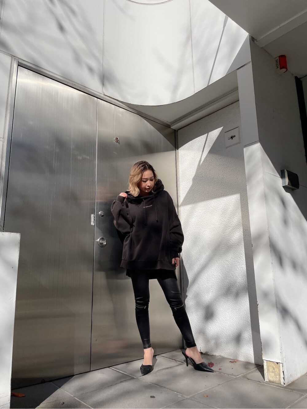 ブラック系のその他パンツ、グレー系のパーカーを着用したレディースの冬コーディネートの3枚目の写真