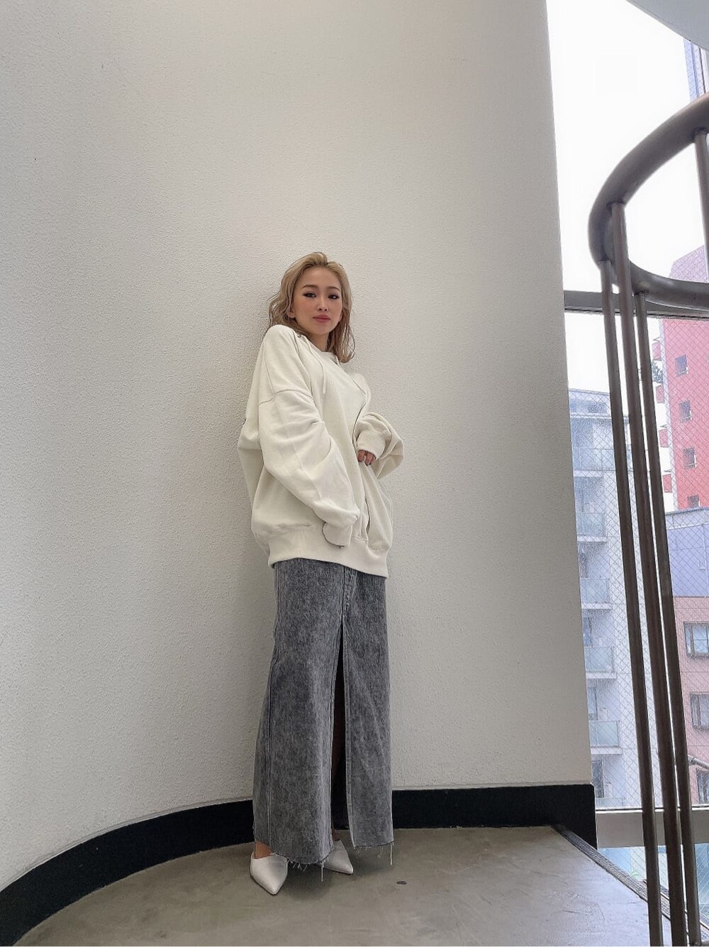 ブラック系のデニムスカート、ホワイト系のパーカーを着用したレディースの夏コーディネートの2枚目の写真