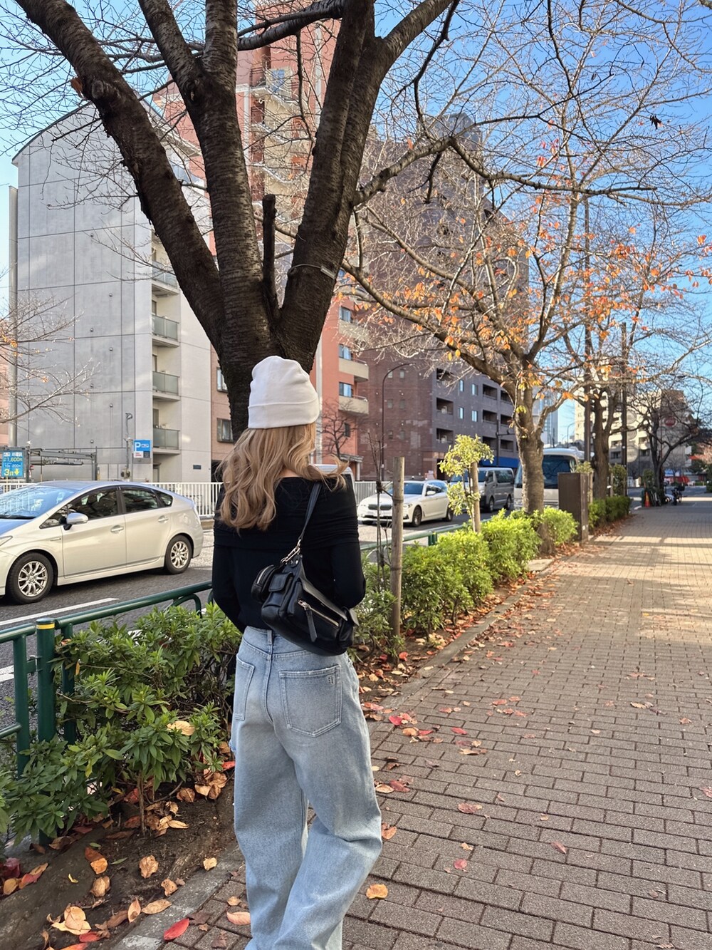 ブラック系のTシャツ/カットソー、ブルー系のデニムパンツ、ホワイト系のニットキャップ/ビーニーを着用したレディースの冬コーディネートの3枚目の写真