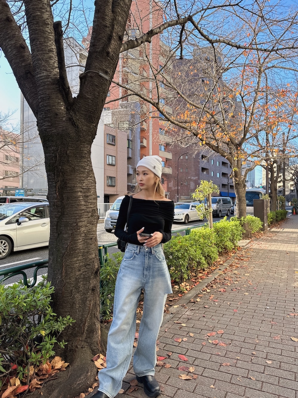 ブラック系のTシャツ/カットソー、ブルー系のデニムパンツ、ホワイト系のニットキャップ/ビーニーを着用したレディースの冬コーディネートの4枚目の写真