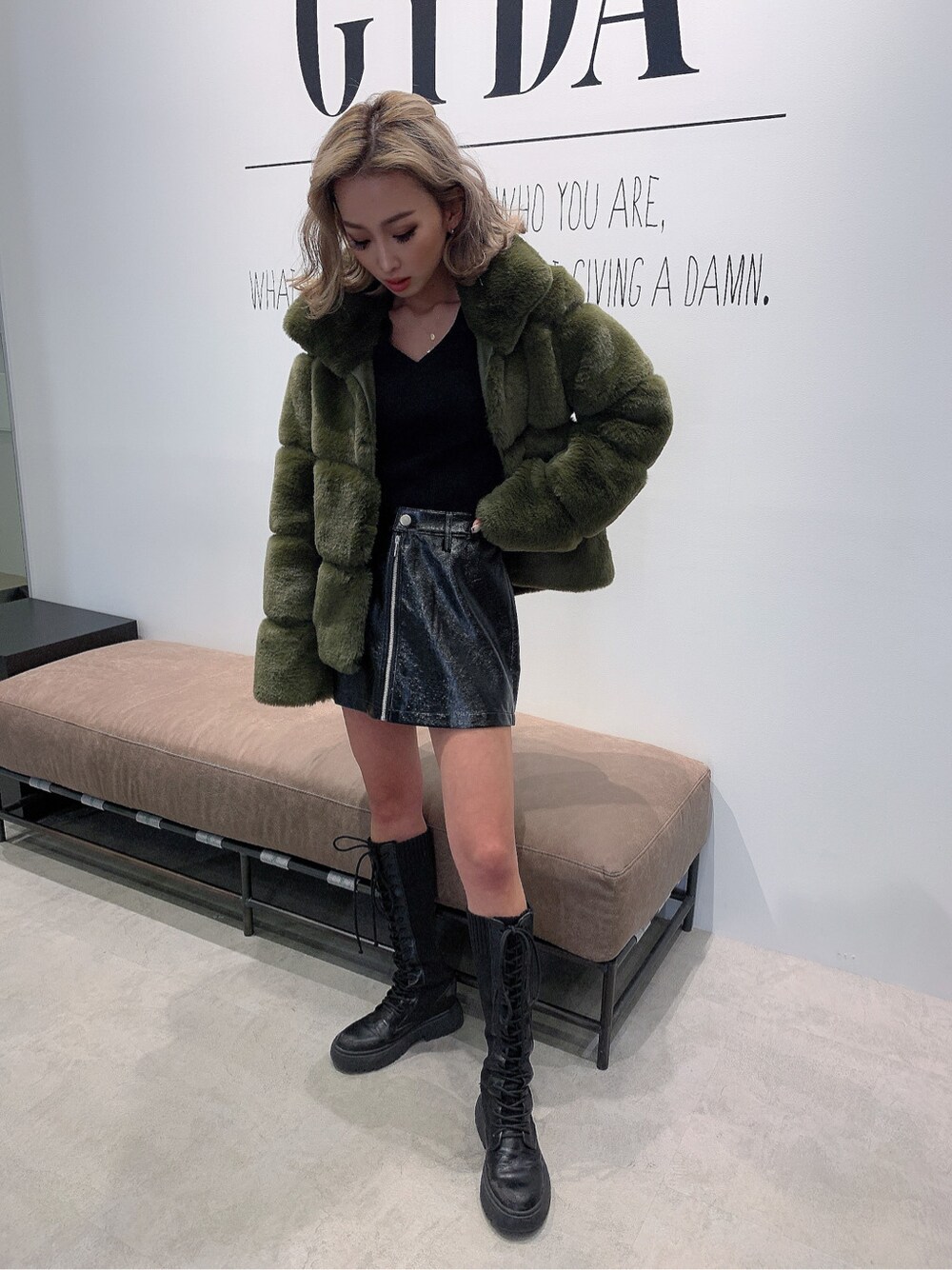 ブラック系のニット/セーター、ベージュ系のムートンコートを着用したレディースの冬コーディネートの3枚目の写真