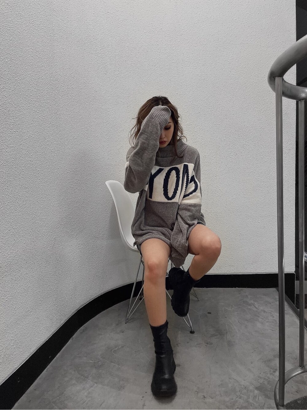 ブラック系のブーツ、ブラック系のその他パンツ、グレー系のニット/セーターを着用したレディースの秋コーディネートの2枚目の写真