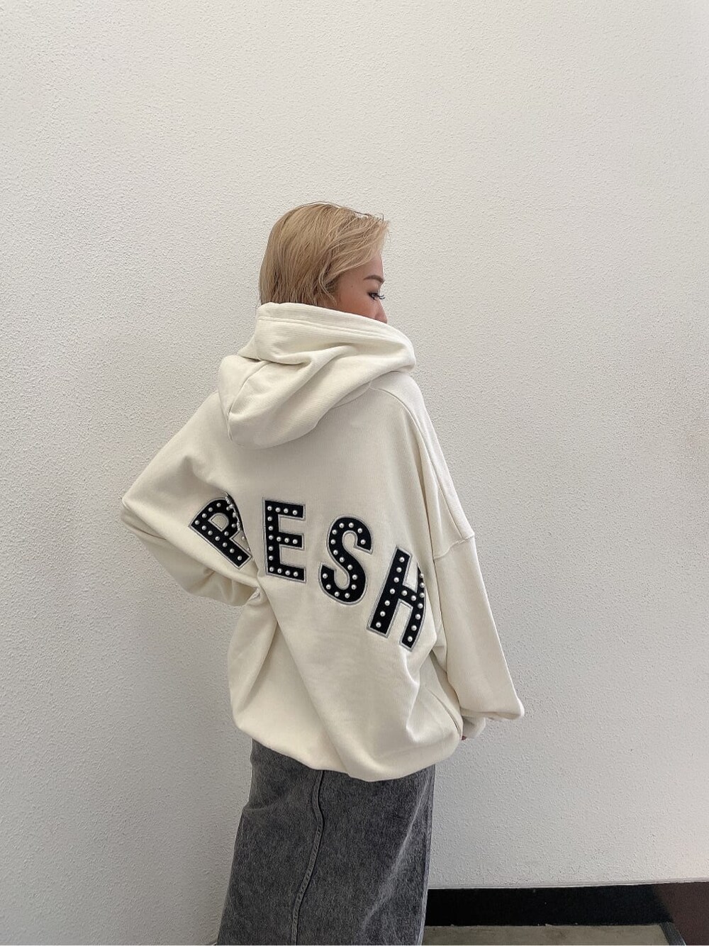 ブラック系のデニムスカート、ホワイト系のパーカーを着用したレディースの夏コーディネートの3枚目の写真