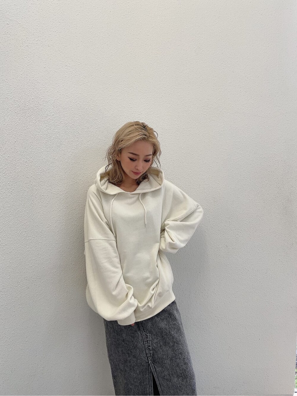 ブラック系のデニムスカート、ホワイト系のパーカーを着用したレディースの夏コーディネートの5枚目の写真