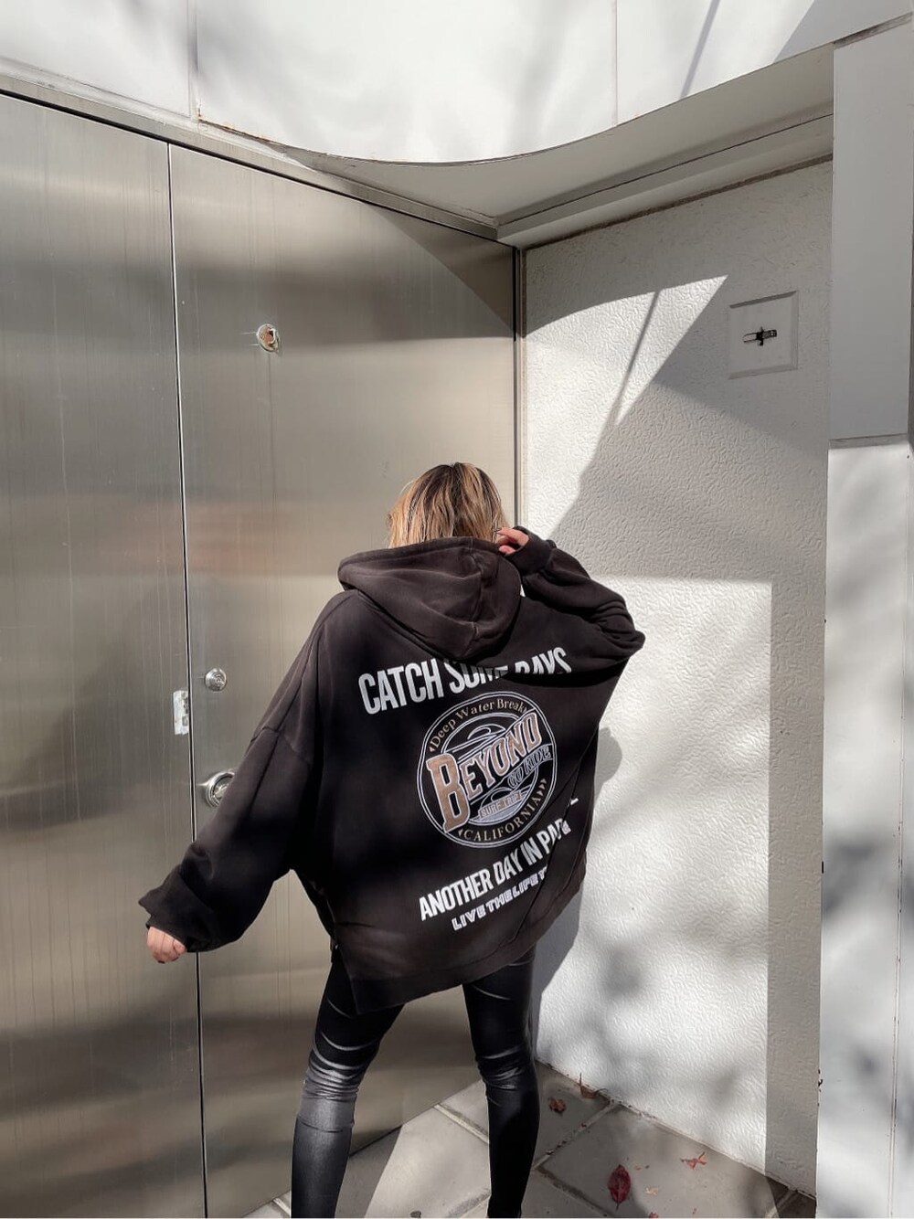 ブラック系のその他パンツ、グレー系のパーカーを着用したレディースの冬コーディネートの6枚目の写真